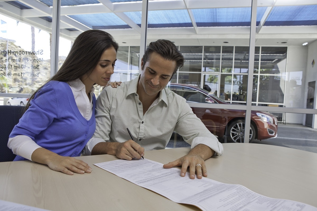 couple signing for a car